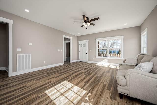 living room featuring dark wood-type flooring and ceiling fan