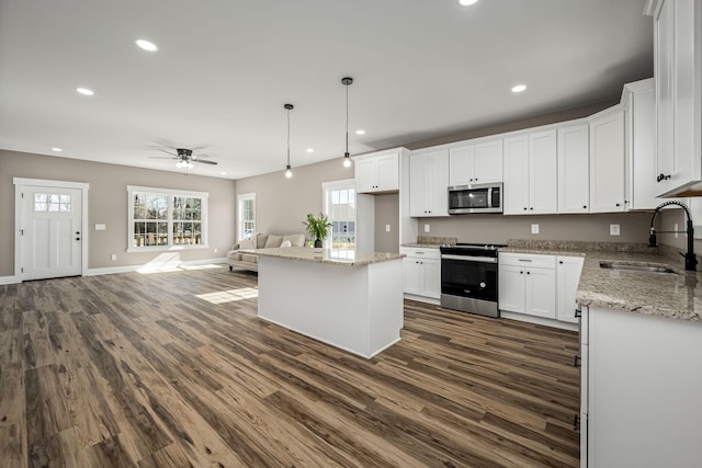 kitchen featuring white cabinetry, stainless steel appliances, a center island, and sink