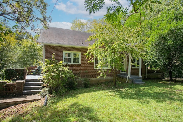 rear view of house featuring a yard