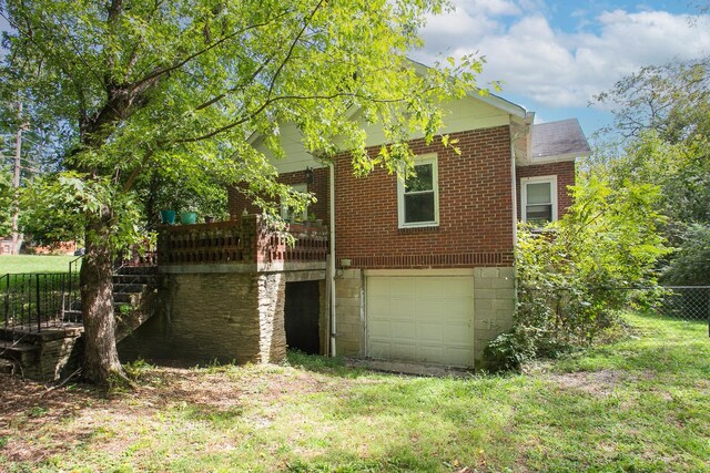 back of property featuring a garage and a deck