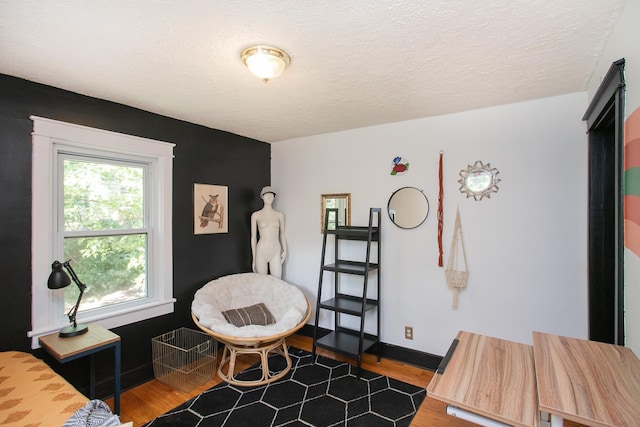 living area with a textured ceiling and hardwood / wood-style flooring