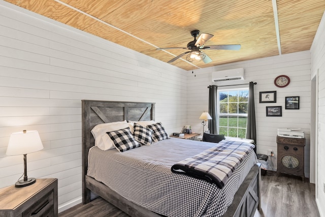 bedroom with wood walls, dark hardwood / wood-style floors, ceiling fan, and a wall unit AC