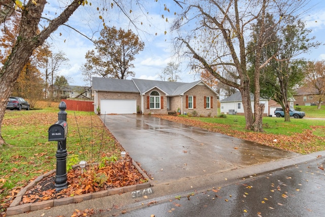 single story home with a garage and a front lawn