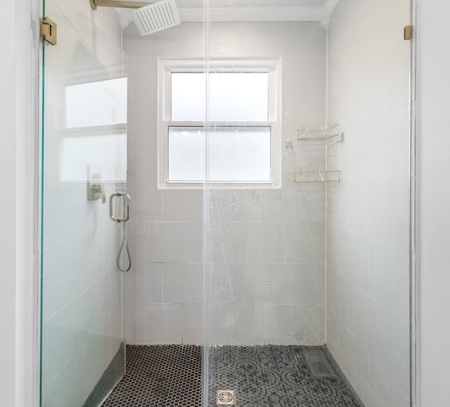 bathroom with a shower with door and ornamental molding