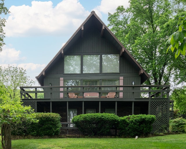 rear view of house featuring a deck and a yard