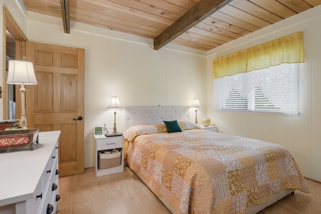 bedroom with beamed ceiling, wood ceiling, and light hardwood / wood-style floors