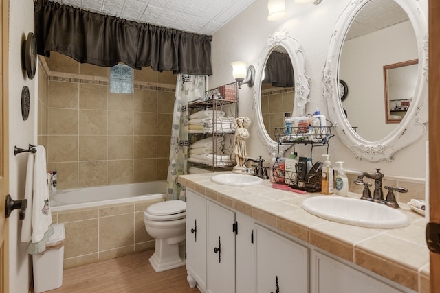 full bathroom with wood-type flooring, shower / bath combination with curtain, vanity, and toilet