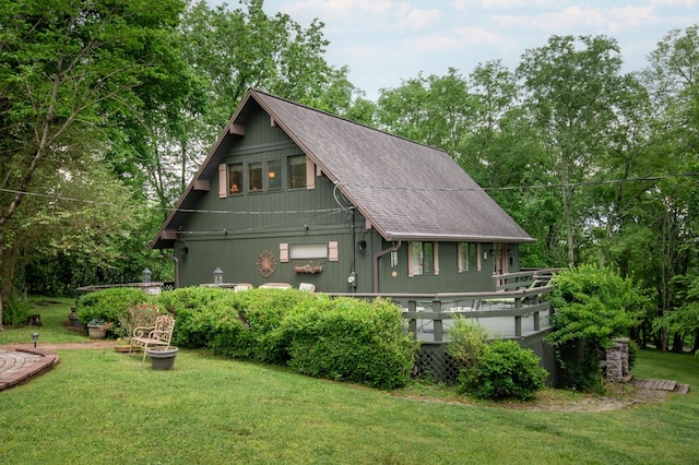 view of side of home with a wooden deck and a yard