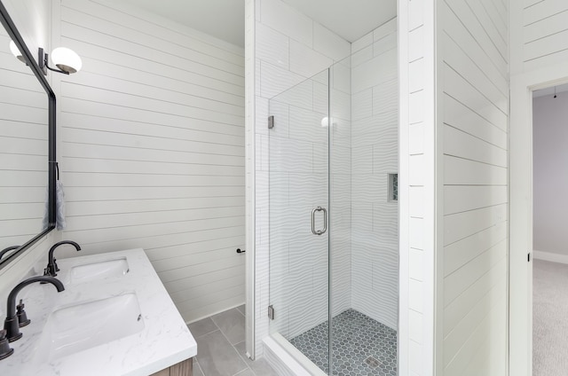 bathroom featuring wood walls, a shower with door, vanity, and tile patterned floors