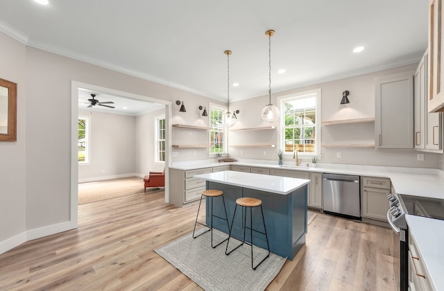 kitchen with ceiling fan, a kitchen island, light hardwood / wood-style flooring, stainless steel appliances, and a kitchen bar