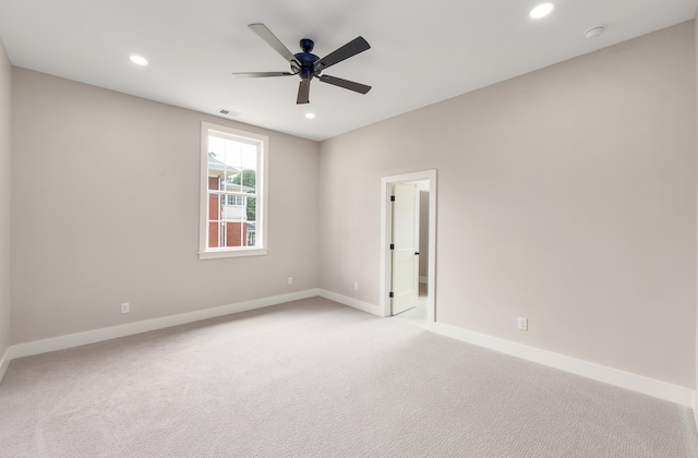 carpeted spare room featuring ceiling fan