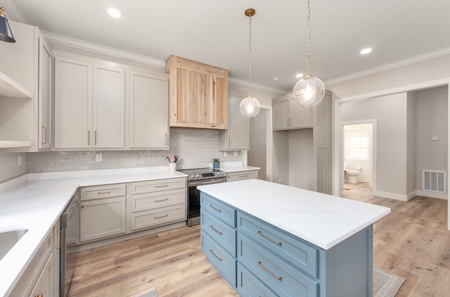 kitchen featuring light wood-type flooring, appliances with stainless steel finishes, hanging light fixtures, and tasteful backsplash