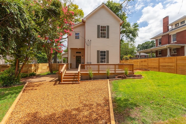 back of house with a deck and a yard