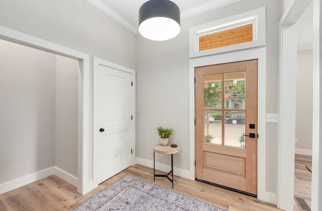 foyer entrance with light wood-type flooring and crown molding