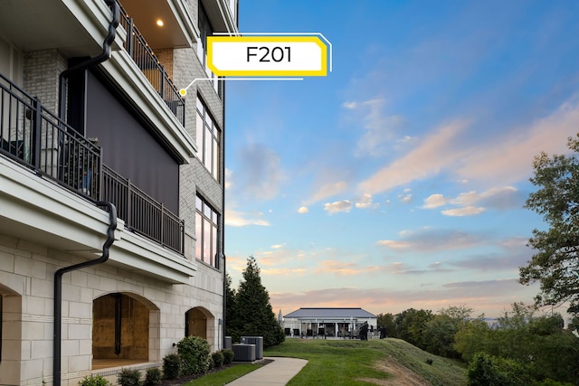 yard at dusk featuring central AC