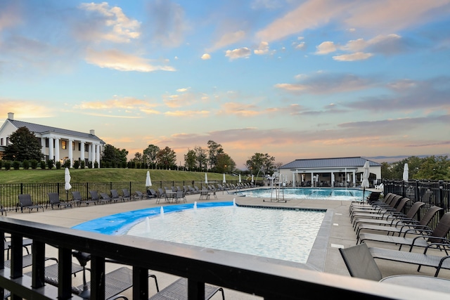 pool at dusk with a patio area