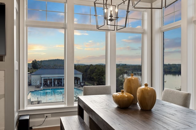 dining room with a notable chandelier and a water view