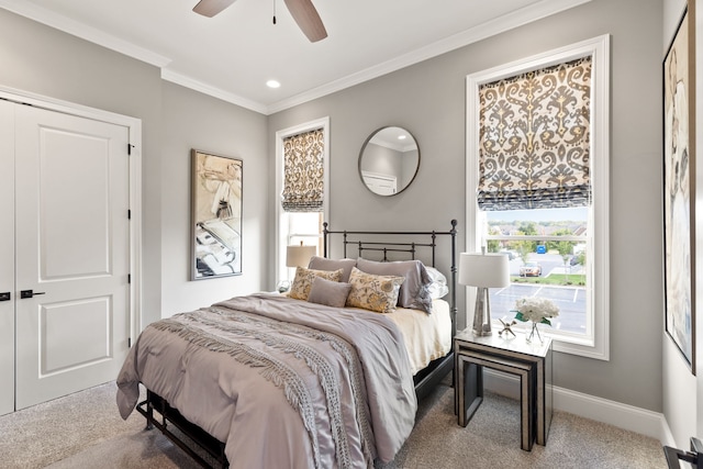 carpeted bedroom with ceiling fan, crown molding, and a closet