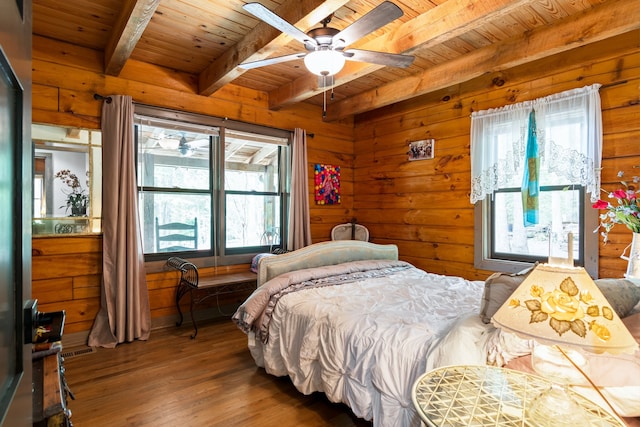 bedroom with multiple windows, beamed ceiling, and hardwood / wood-style flooring