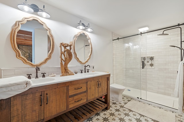 bathroom featuring vanity, a shower with shower door, and toilet