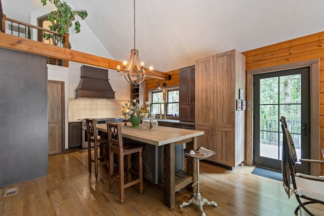 dining area with wooden walls, plenty of natural light, and light hardwood / wood-style floors