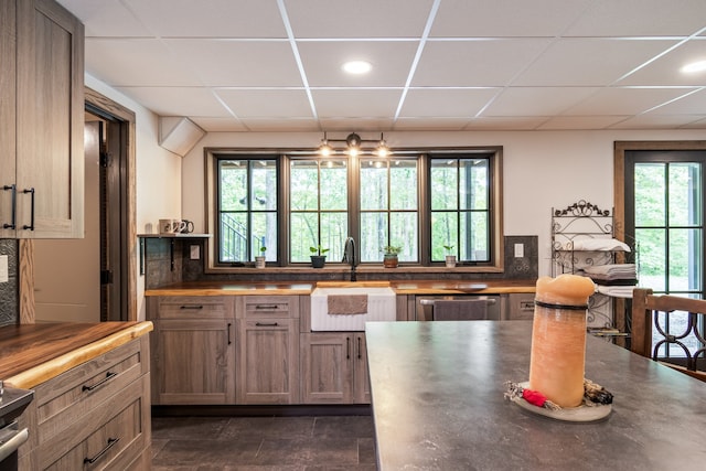 kitchen featuring a drop ceiling, a healthy amount of sunlight, and sink