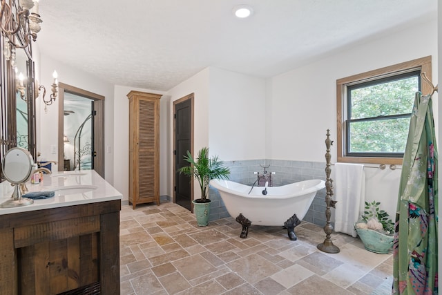 bathroom featuring tile walls, vanity, and a tub