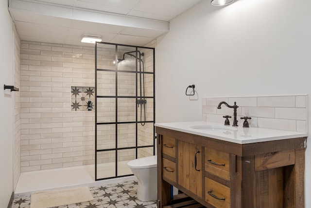 bathroom featuring tiled shower, vanity, and toilet