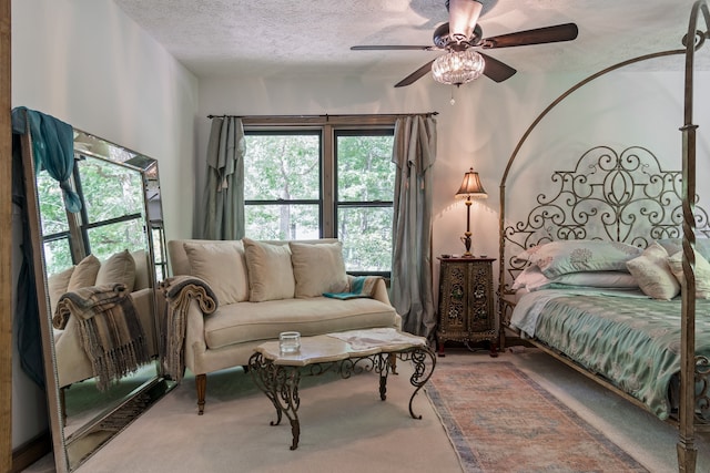 bedroom featuring ceiling fan, a textured ceiling, and carpet flooring