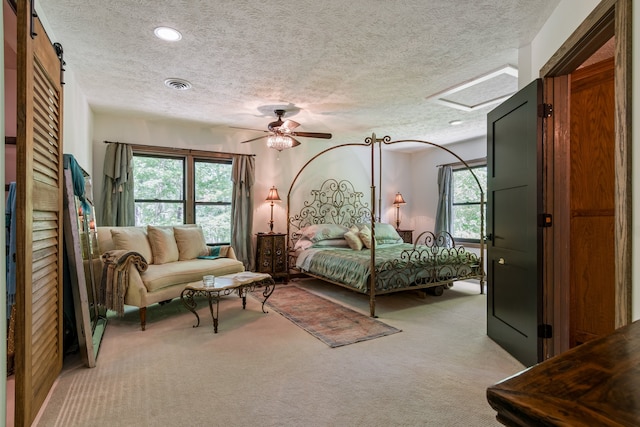 carpeted bedroom with ceiling fan, multiple windows, and a textured ceiling