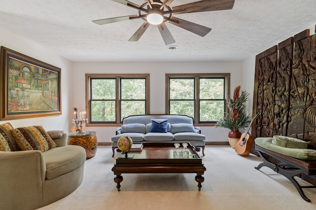 carpeted living room with a textured ceiling and ceiling fan