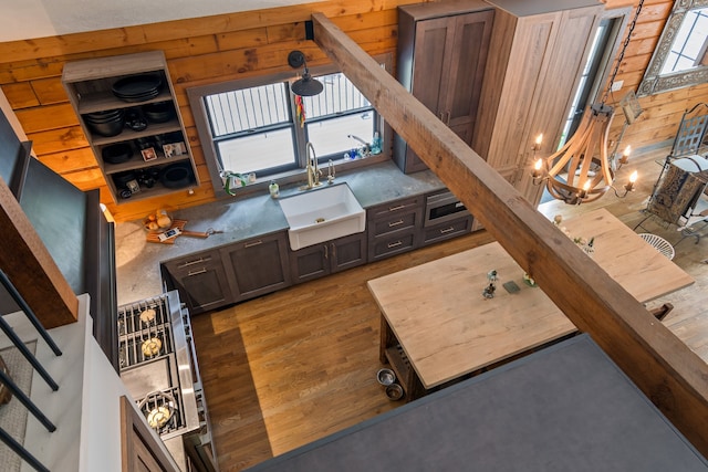 living room featuring wood walls, hardwood / wood-style floors, a chandelier, and sink