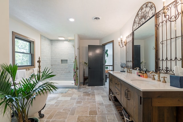 bathroom with a tile shower, a textured ceiling, and vanity