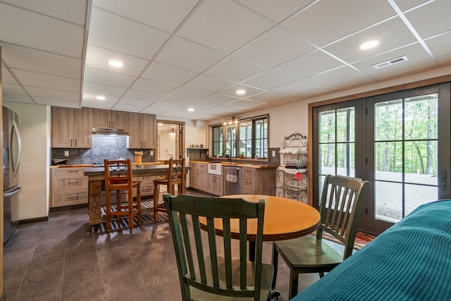 tiled dining room with a drop ceiling and sink