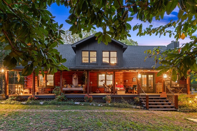 back house at dusk with a wooden deck