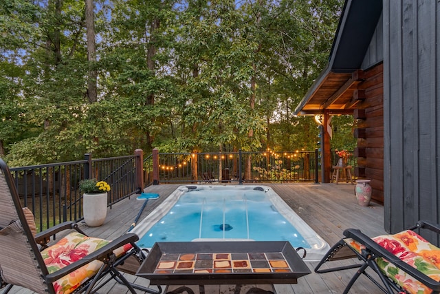 view of swimming pool featuring a deck and a fire pit