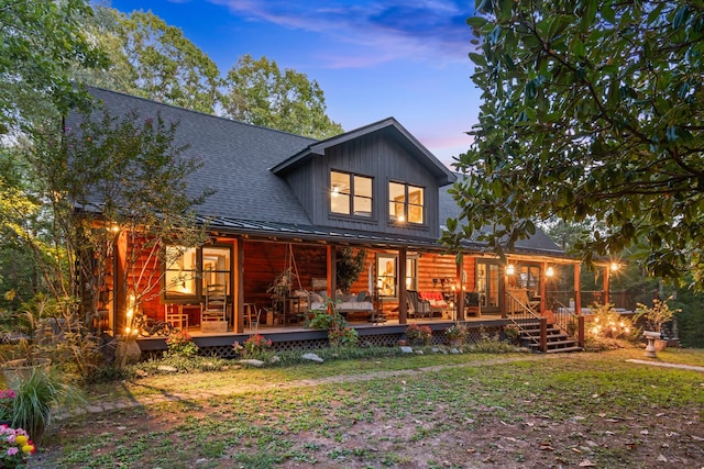 back house at dusk with a wooden deck