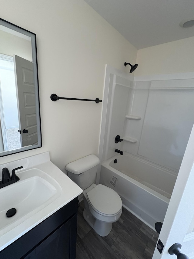 full bath with shower / bathtub combination, vanity, wood finished floors, and toilet