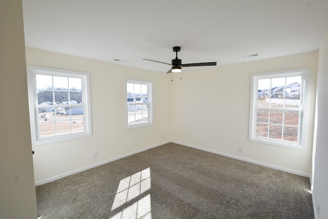 spare room with carpet, visible vents, baseboards, and ceiling fan