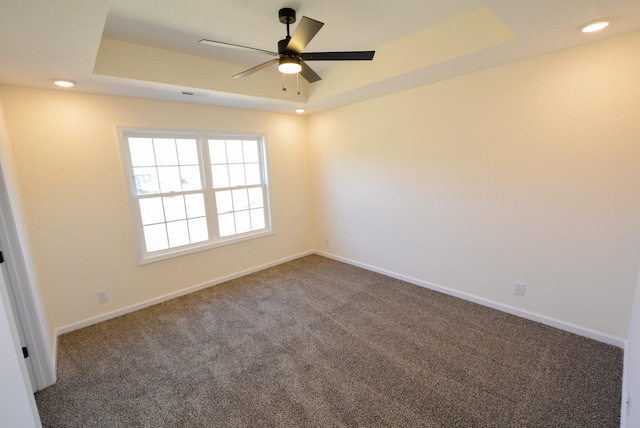 carpeted empty room featuring baseboards, a tray ceiling, ceiling fan, and recessed lighting