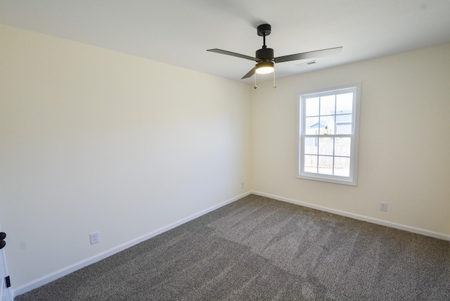 empty room featuring a ceiling fan, visible vents, dark carpet, and baseboards