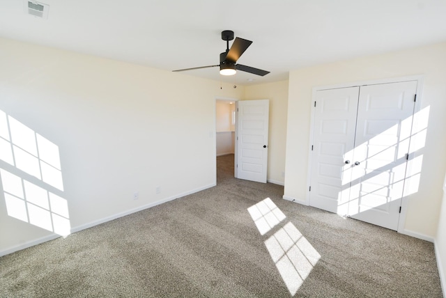 unfurnished bedroom featuring carpet floors, visible vents, baseboards, and a ceiling fan