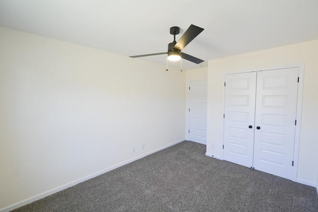 unfurnished bedroom featuring a ceiling fan, baseboards, dark carpet, and a closet