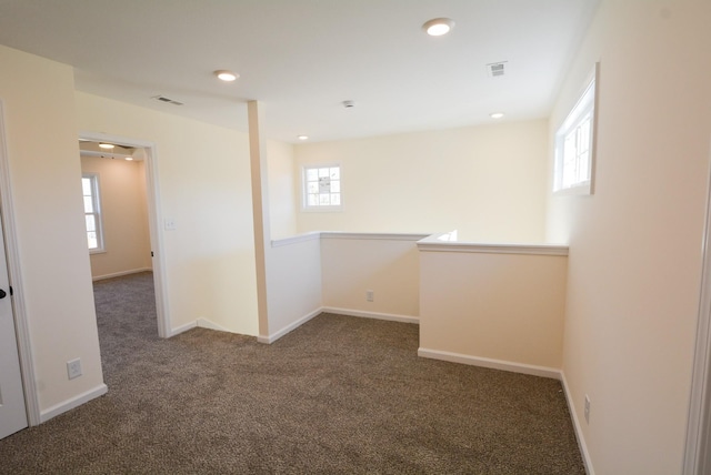 carpeted spare room featuring recessed lighting, visible vents, and baseboards