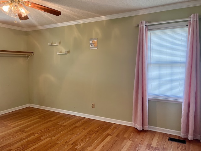 interior space with ornamental molding, light hardwood / wood-style floors, ceiling fan, and a textured ceiling