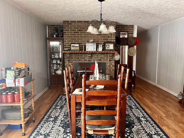 dining space with an inviting chandelier, a textured ceiling, and hardwood / wood-style floors