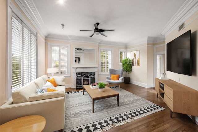 living room featuring a high end fireplace, dark hardwood / wood-style floors, ceiling fan, and a wealth of natural light