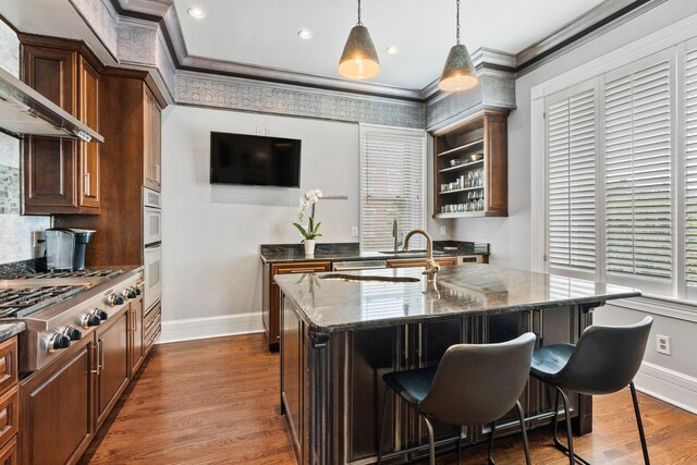 kitchen with stainless steel appliances, dark stone counters, baseboards, wall chimney range hood, and ornamental molding