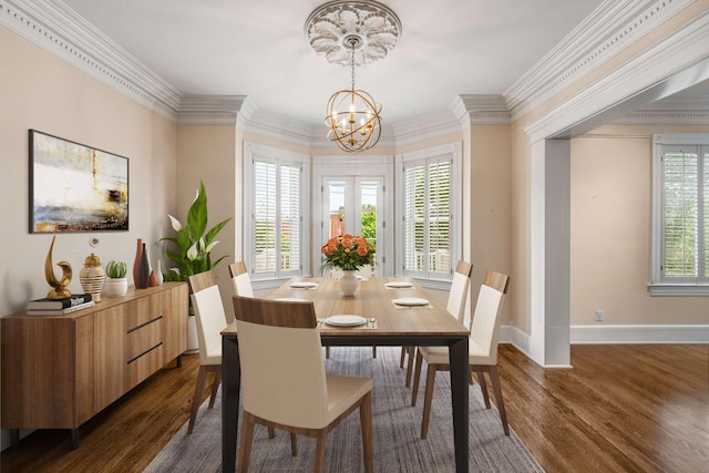 dining room featuring dark wood finished floors, baseboards, crown molding, and a chandelier