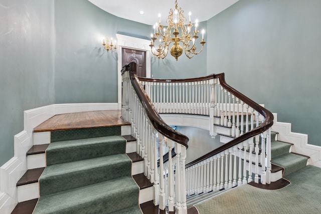 stairs featuring a notable chandelier